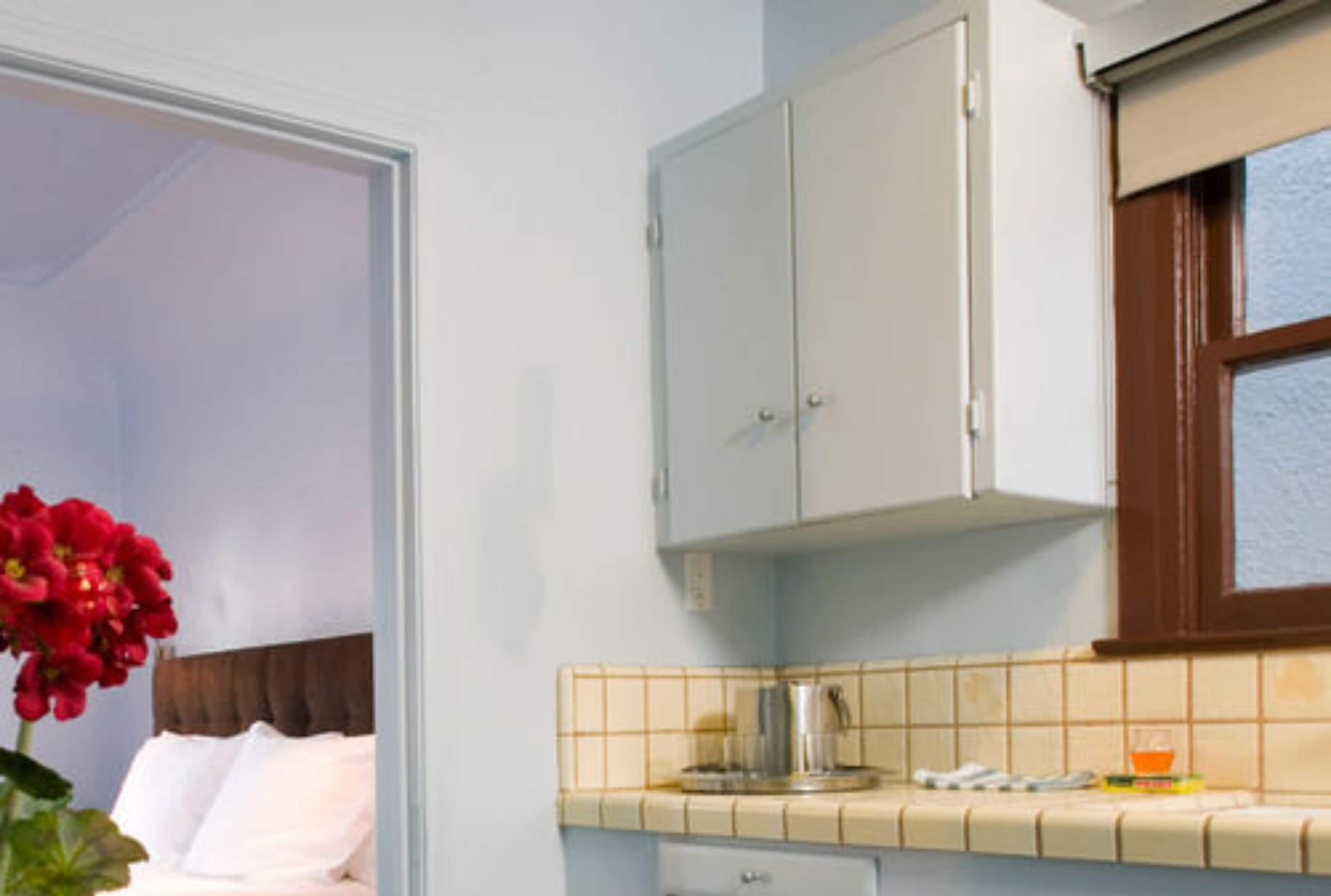 Un dormitorio con cama, mesita de noche y ventana.
