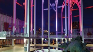 A nighttime view of a modern architectural structure with illuminated arches and a reflective pool. - Seattle Gaslight Inn (Seattle)