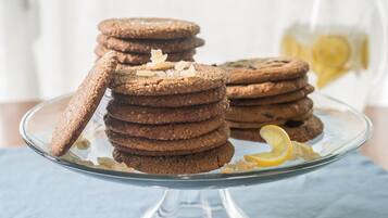 A stack of cookies on a glass plate with a lemon slice.