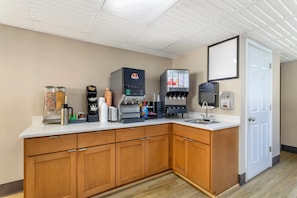 Una kitchenette equipada con cafetera, microondas y refrigerador.