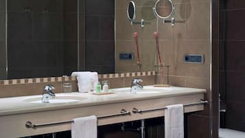 A modern bathroom with two sinks, a large mirror, and a toilet.