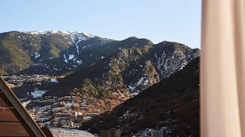 Un paisaje montañoso con un pueblo en el valle.