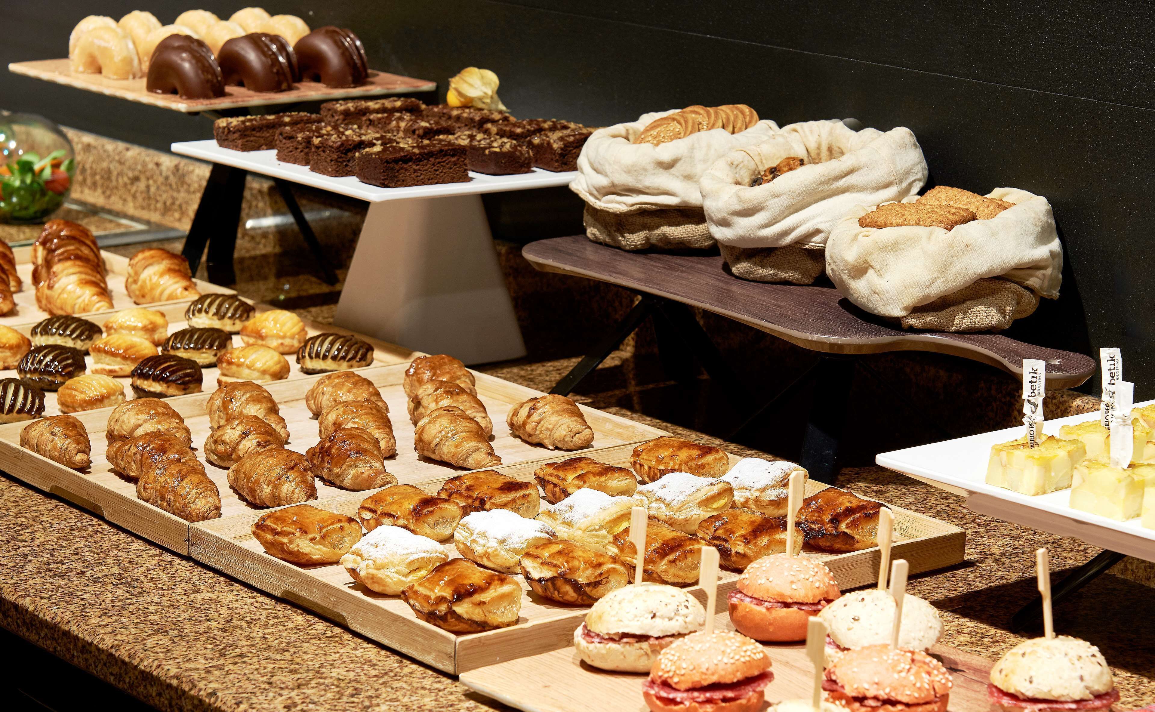 A variety of pastries and desserts displayed on wooden boards.