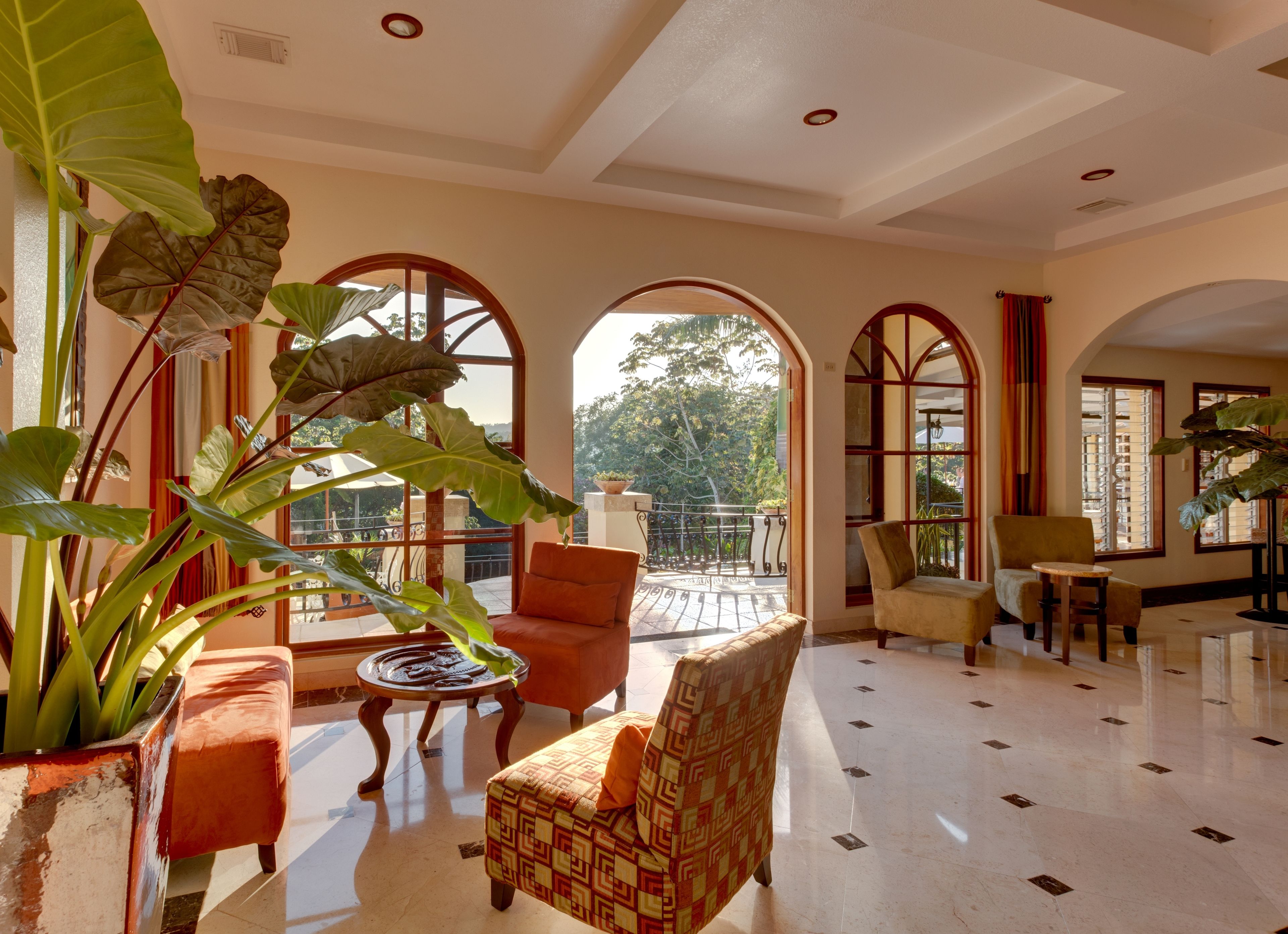 A spacious lobby with a high ceiling, large windows, and a balcony with a view of the outdoors.