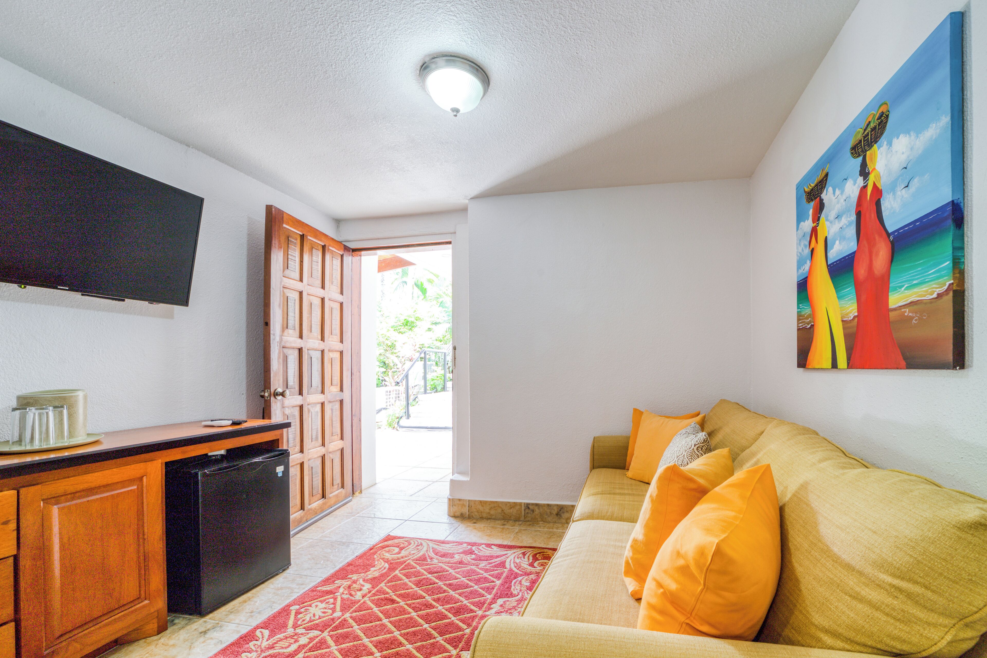 A living room with a sofa, a TV, and a painting.