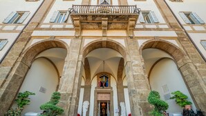 A historic building with three arches, a central balcony, and statues flanking the entrance. - Villa Tuscolana (Frascati)