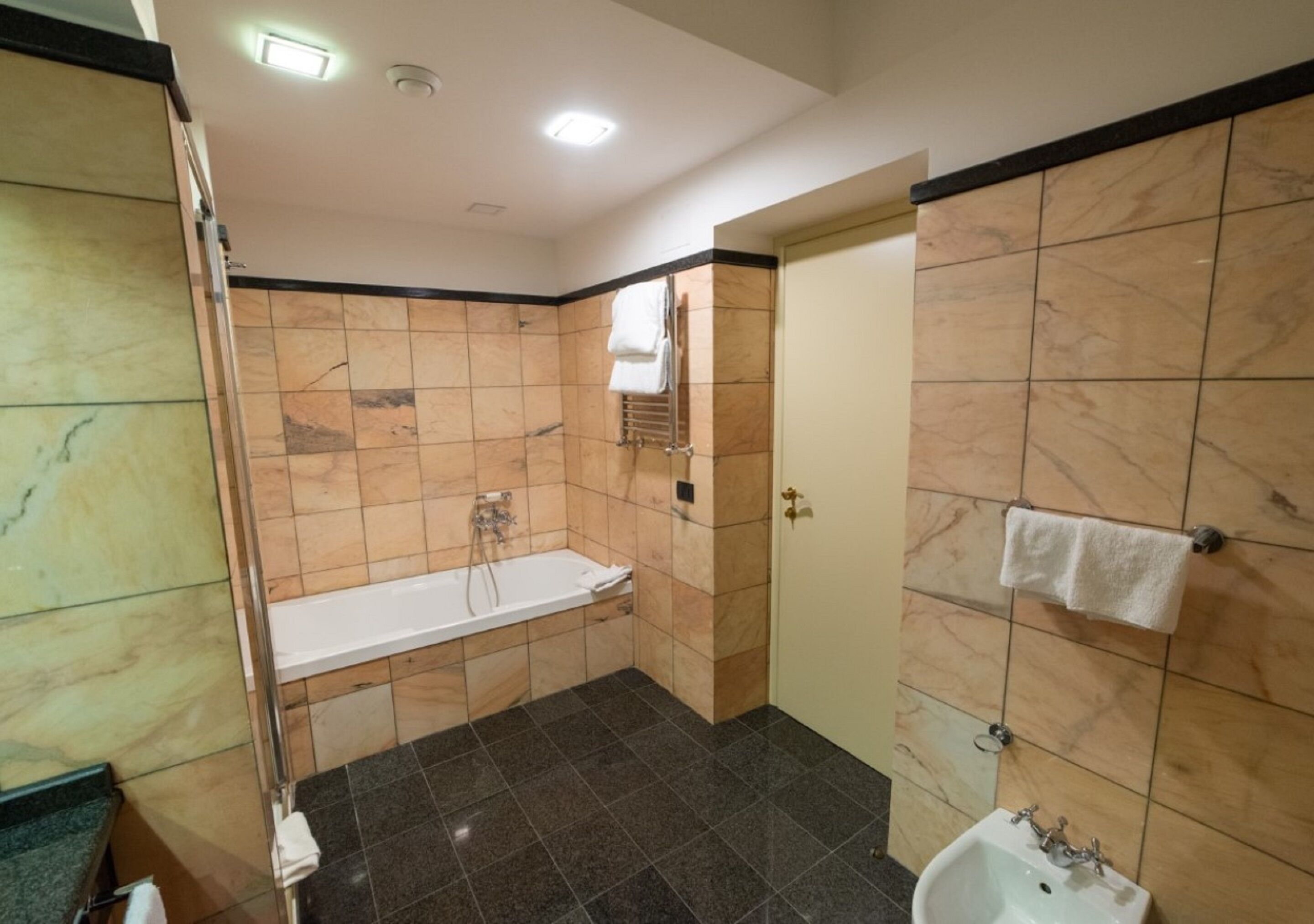 Un baño con bañera, ducha y lavamanos.