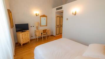 Una camera da letto con un letto, una scrivania, una sedia, una televisione e applique.
