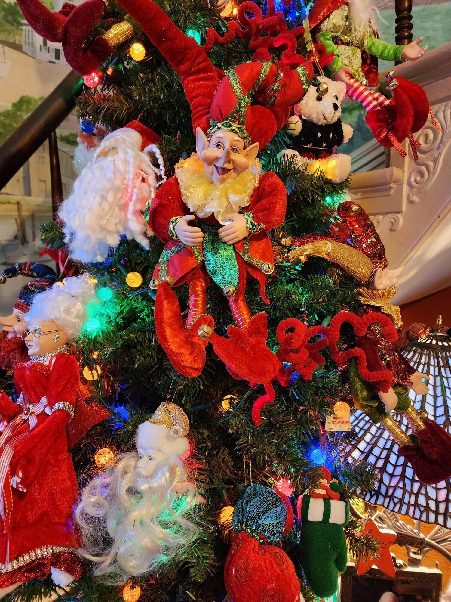 A Christmas tree with various ornaments including a Santa Claus figure, a reindeer, and other festive decorations.