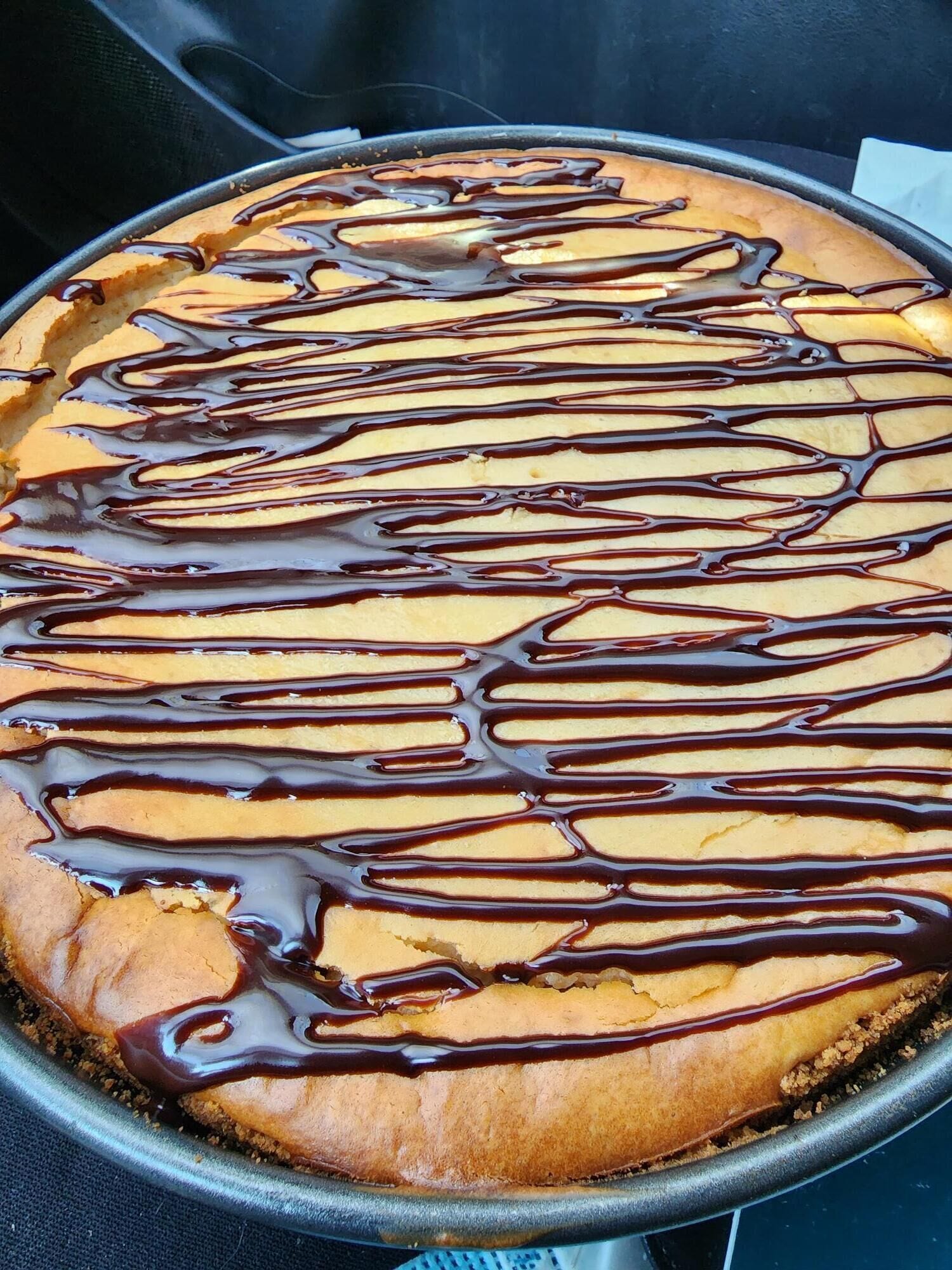 Un dessert nappé de chocolat, présenté dans un plat de cuisson rond.