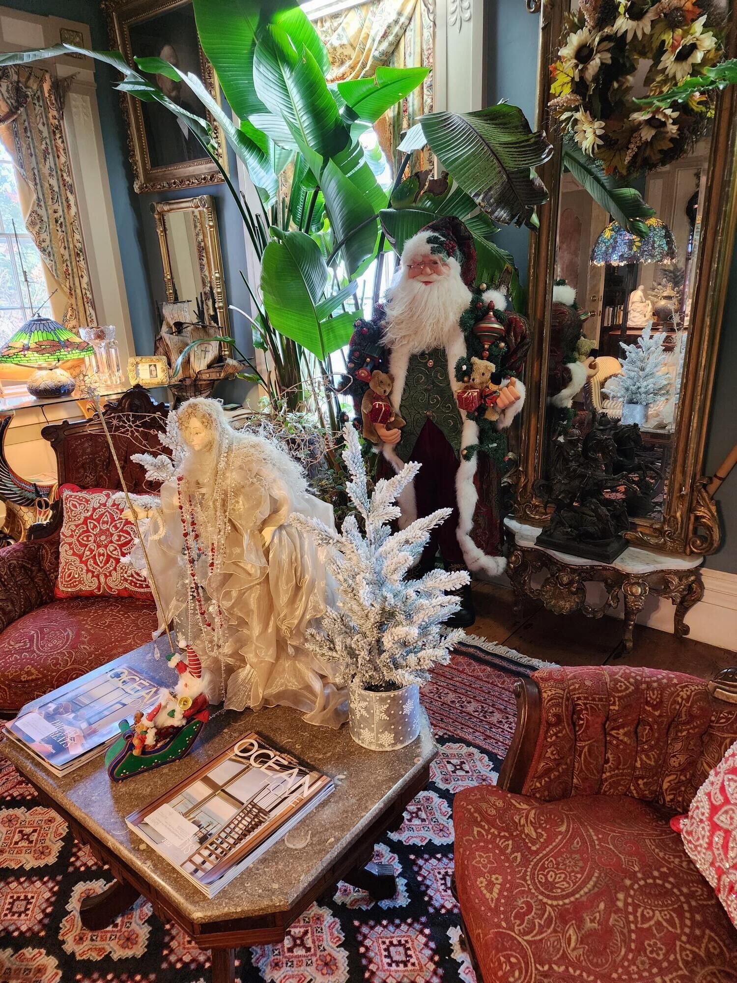 A cozy living room with a plush sofa, a decorative Christmas tree, and a vintage-style fireplace.