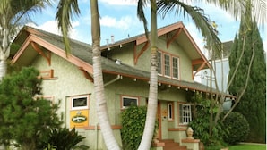 A two-story house with a sloped roof, a front porch, and a well-maintained lawn.
