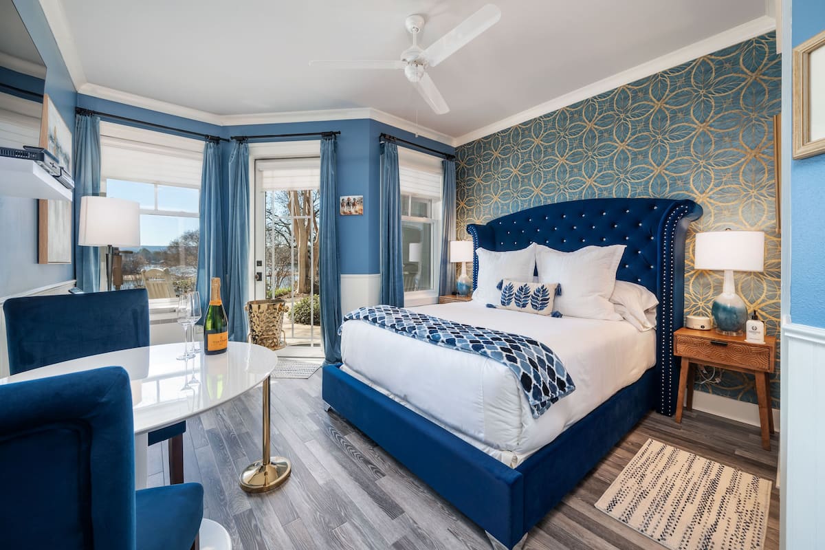 A bedroom with a large bed, a dining table, and chairs.