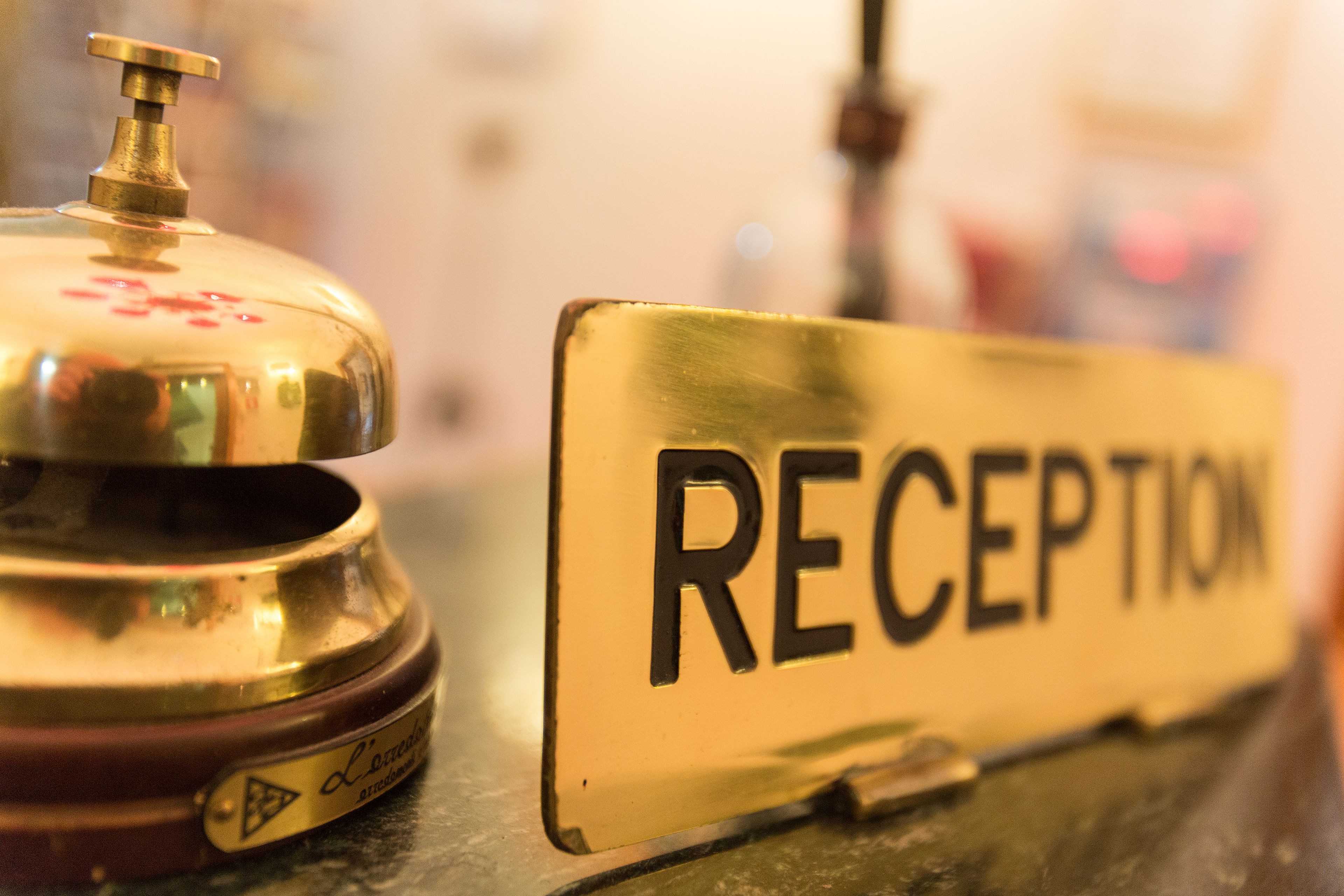 Un comptoir d’accueil avec une pancarte indiquant « RÉCEPTION » et une cloche.