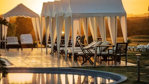 A poolside area with lounge chairs and a tented structure. - Arapey Thermal Resort & Spa (Termas del Arapey)