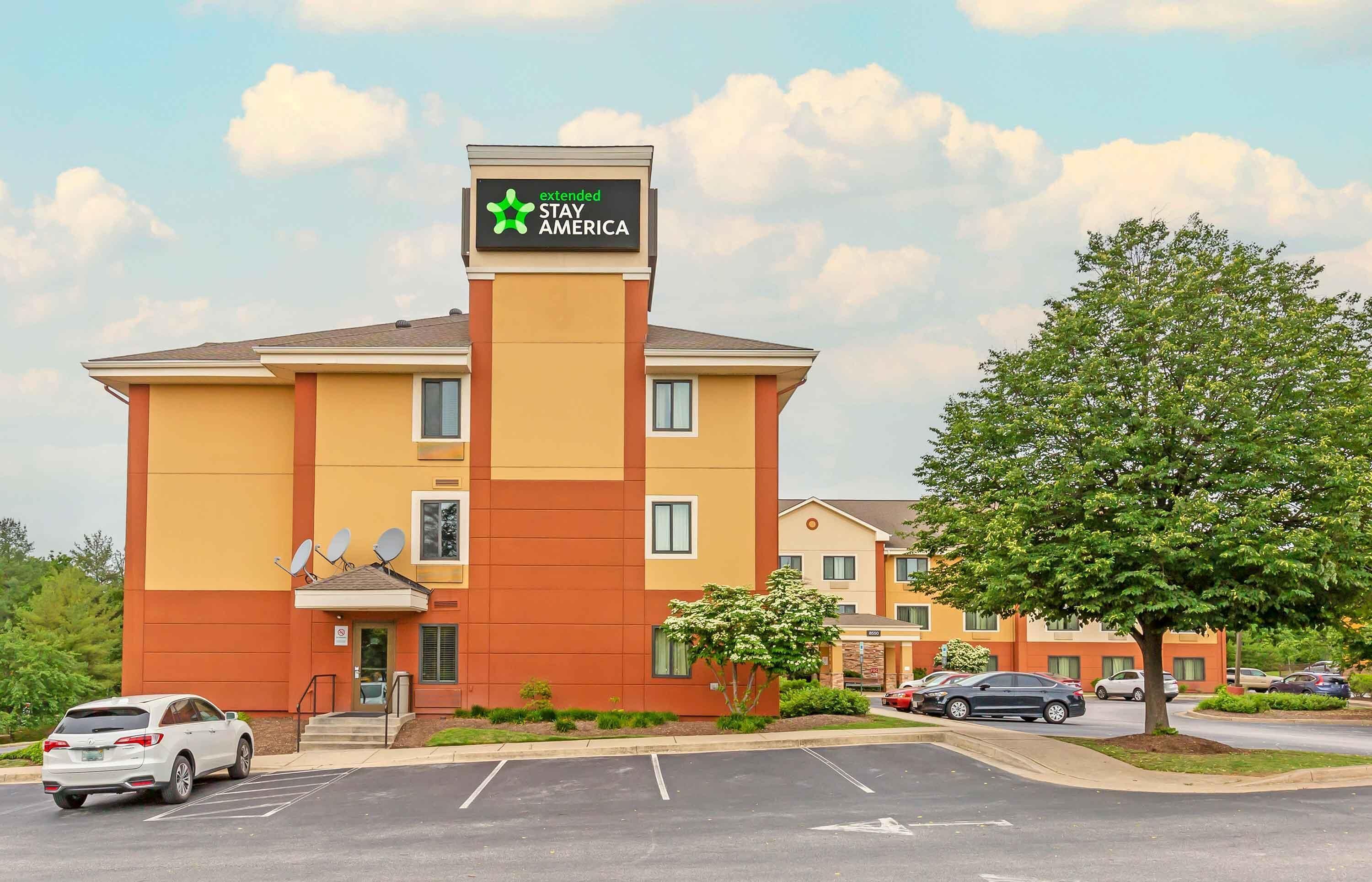 Een meerhoog hotel met een bord waarop staat 'extended STAY AMERICA'.