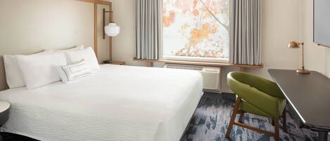 Una habitación de hotel con una cama grande, un escritorio, una silla y una ventana con cortinas.