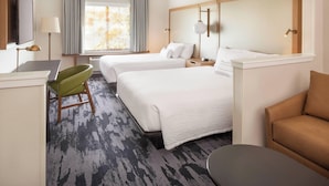 A hotel room with two beds, a desk, a green chair, a brown sofa, and a TV. - Fairfield Inn & Suites by Marriott Napa American Canyon (American Canyon)