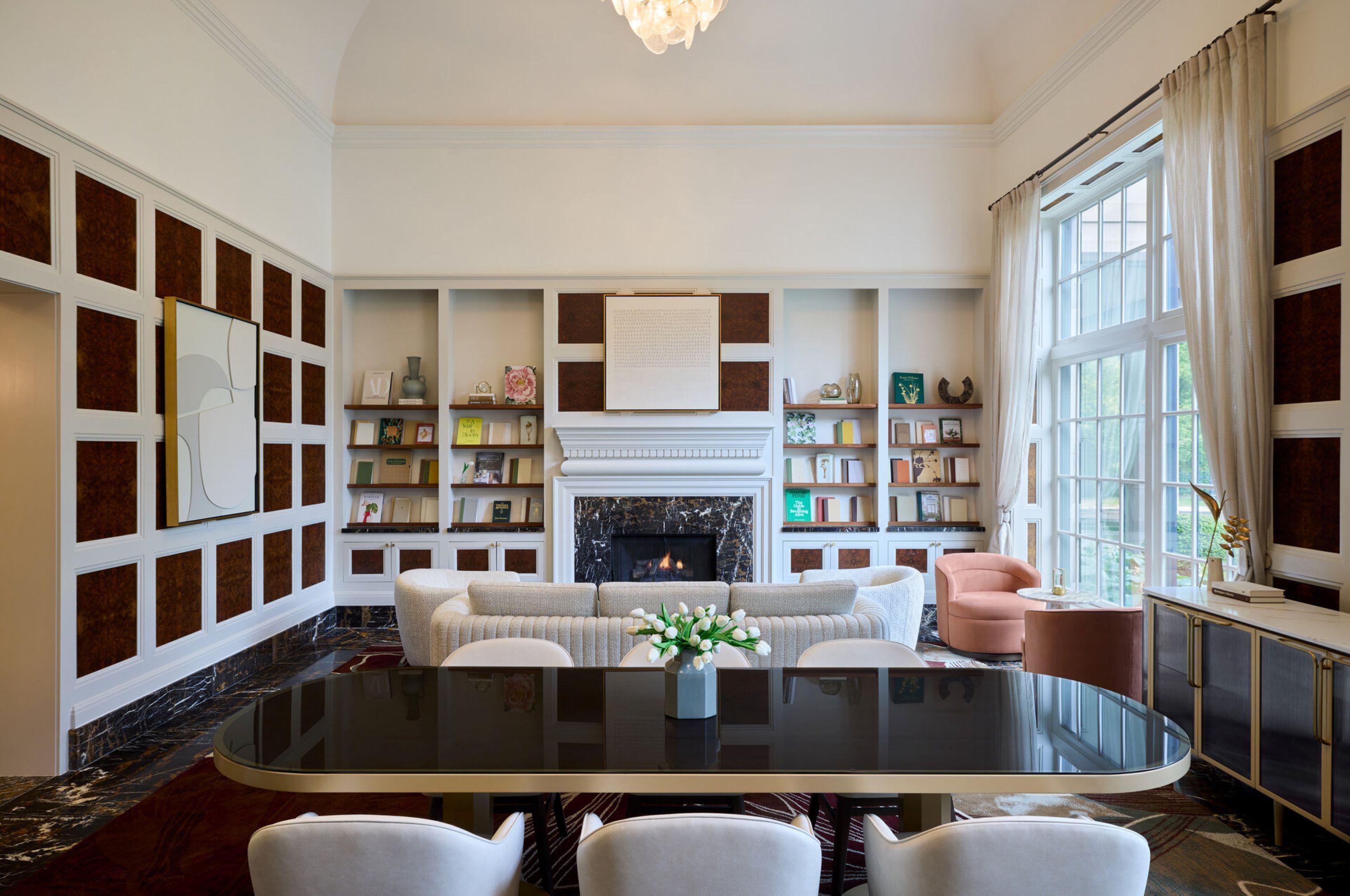 A spacious living room with a fireplace, a round glass table, and a comfortable seating area.