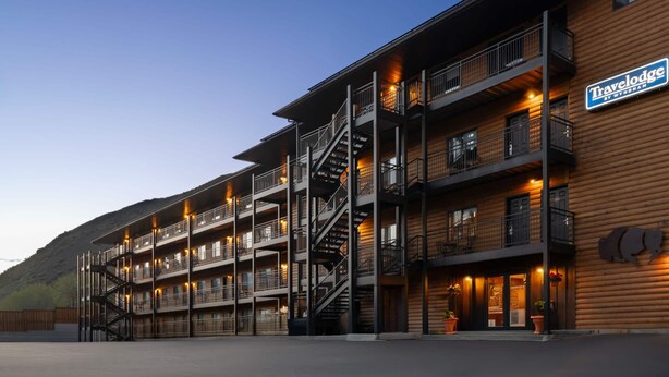 A multi-story building with balconies, a staircase, and a sign for 'Travelodge.'