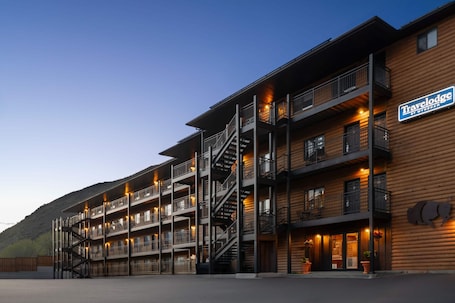 A multi-story building with balconies, a staircase, and a sign for 'Travelodge.'