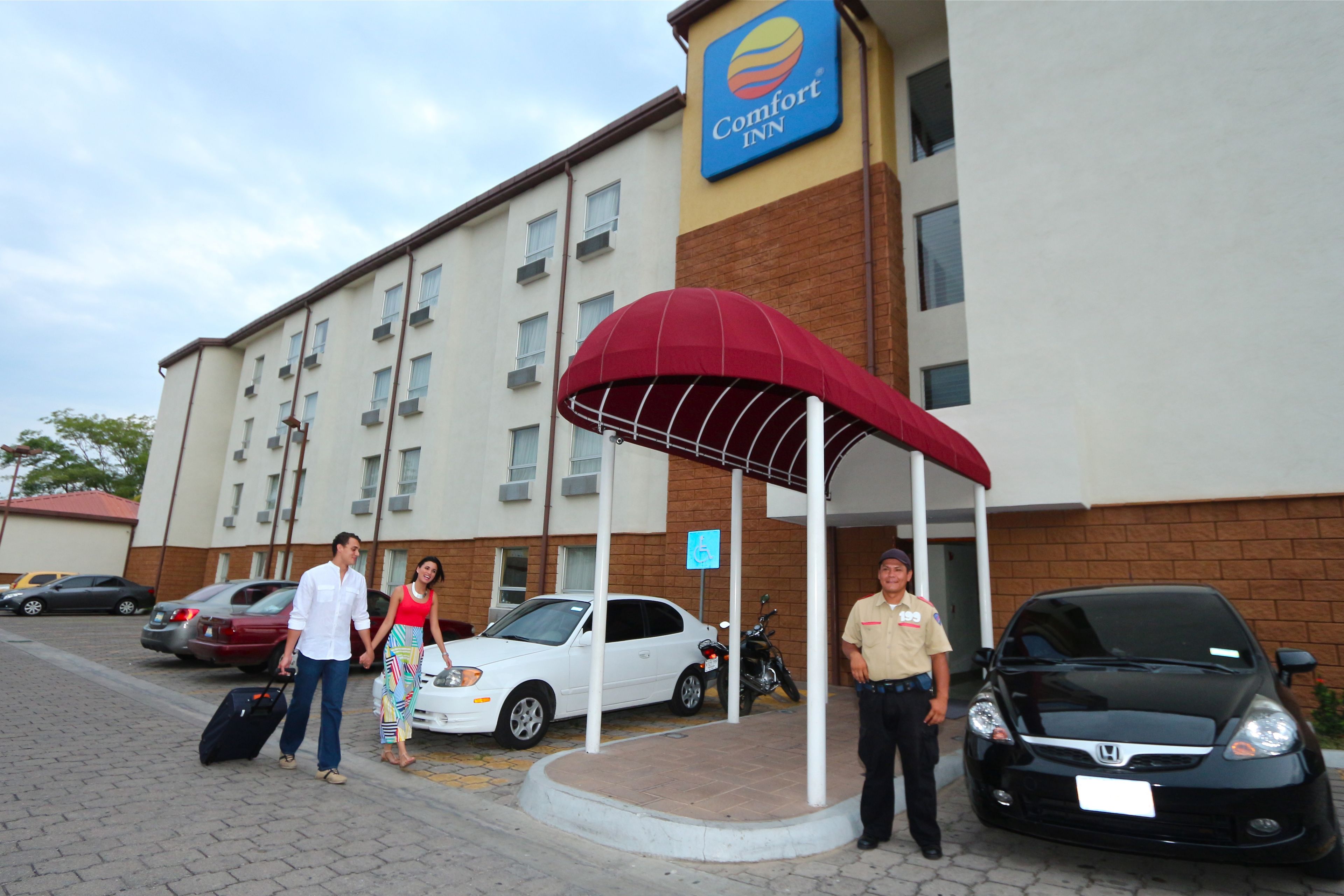 A Comfort Inn hotel with a covered entrance, a parking area, and a sign indicating handicap accessibility.