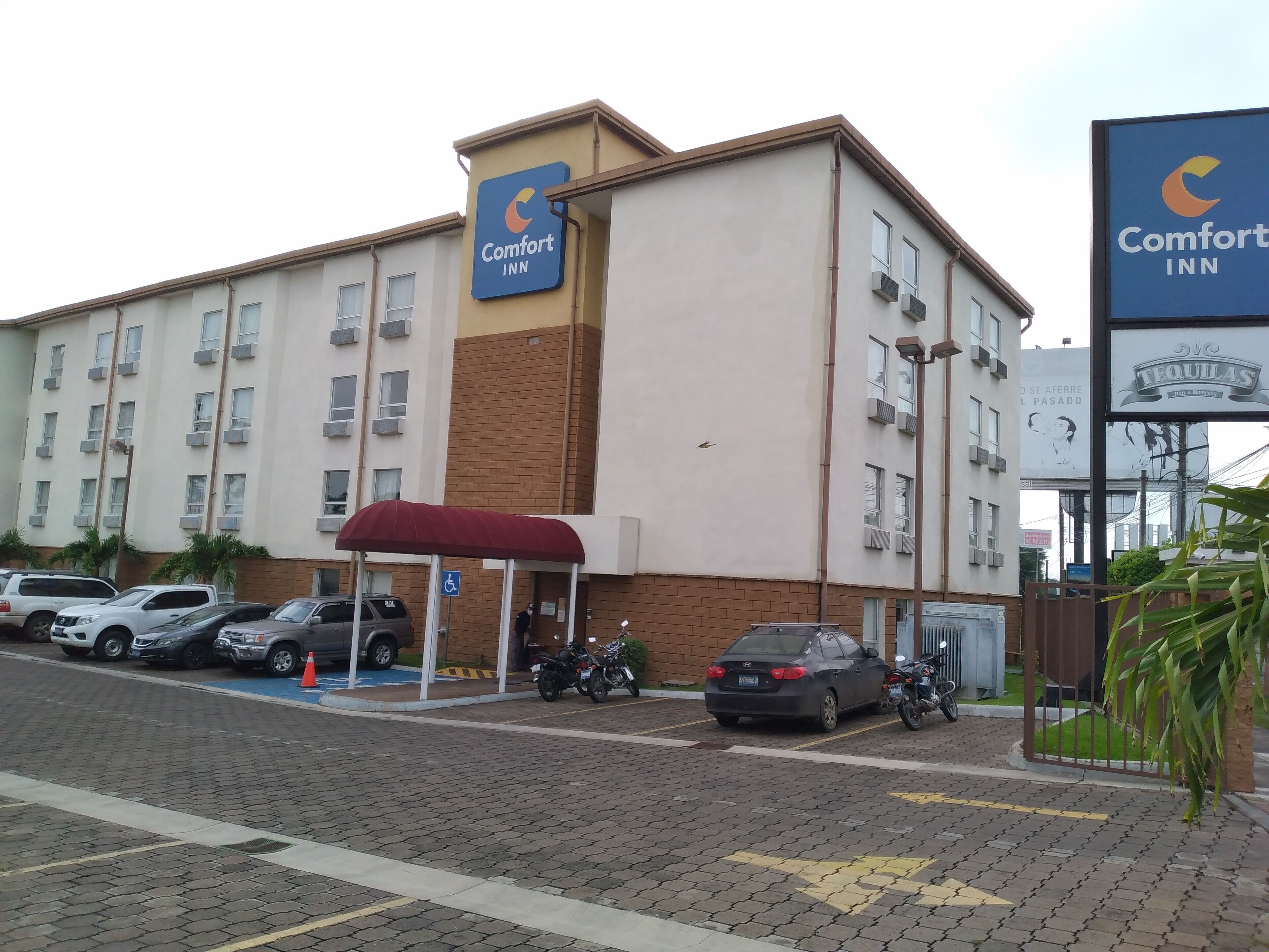 Un hôtel Comfort Inn doté d’un parking, d’une entrée couverte et d’un panneau indiquant l’emplacement d’un bar à tequila situé à proximité.
