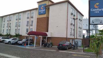 Un hôtel Comfort Inn doté d’un parking, d’une entrée couverte et d’un panneau indiquant l’emplacement d’un bar à tequila situé à proximité.