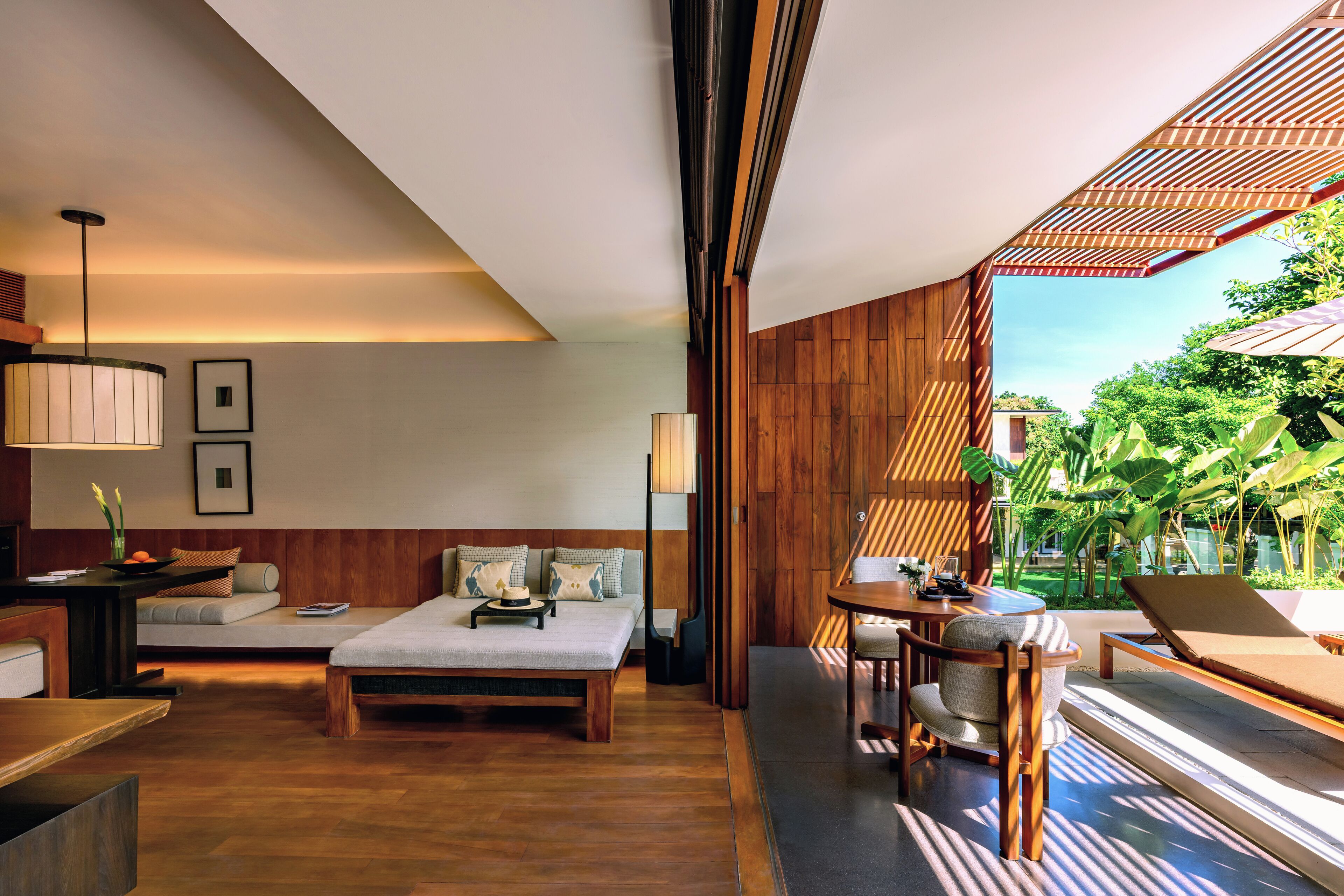 Una habitación de hotel moderna con cama, zona de estar y vistas al exterior.