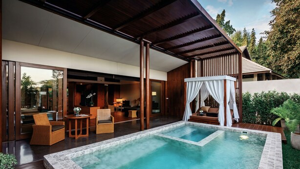 Un espace piscine extérieur moderne doté d’une terrasse en bois, d’un coin salon couvert et d’un auvent blanc.