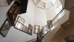 Una escalera de caracol con vistas al piso superior y un techo con tragaluces.