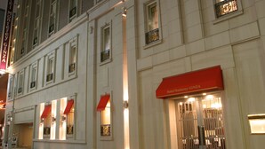 Fachada de hotel con un llamativo toldo rojo y un letrero que dice "Hotel Monterrey Ginza".