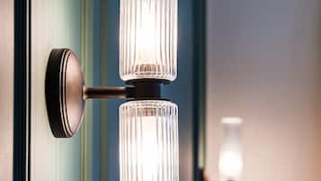 Un luminaire mural doté de deux abat-jour en verre cylindriques.