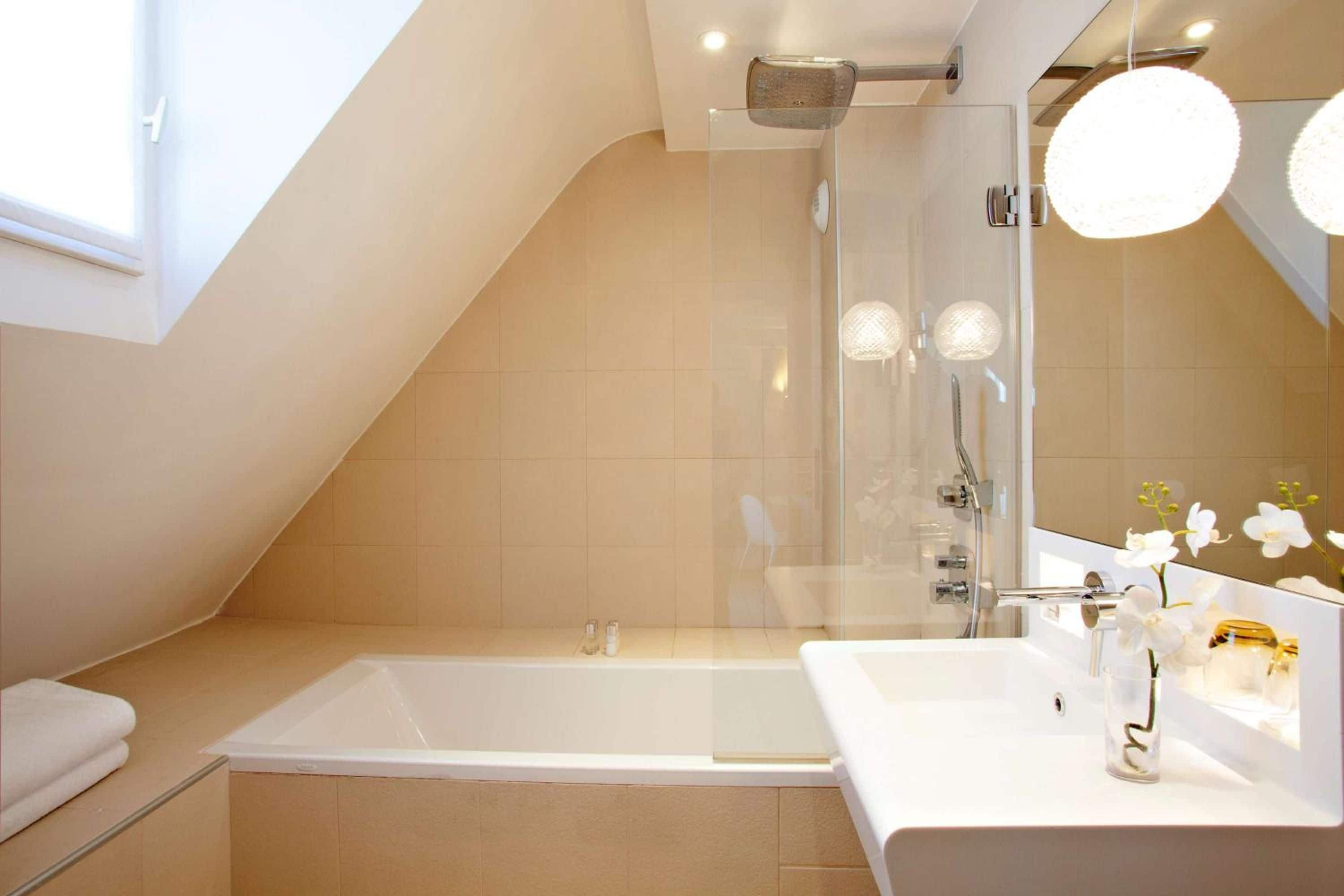 A modern bathroom with a bathtub, a shower, and a vanity with a mirror.