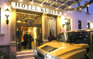 El exterior del Hotel Kubler con un clásico coche amarillo estacionado al frente.