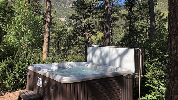 Un jacuzzi en zona boscosa, con un cartel que indica que es solo para adultos.