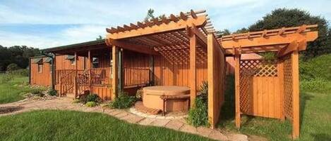 Una estructura de madera con una pérgola y un pequeño espacio al aire libre para sentarse.