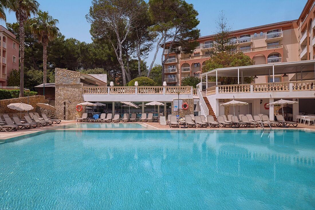 Una piscina al aire libre de temporada, sombrillas, tumbonas