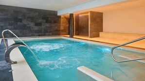 A swimming pool with a modern design, including a glass enclosure and a metal ladder. - Canyamel Classic & Spa, solo Adultos (Capdepera)