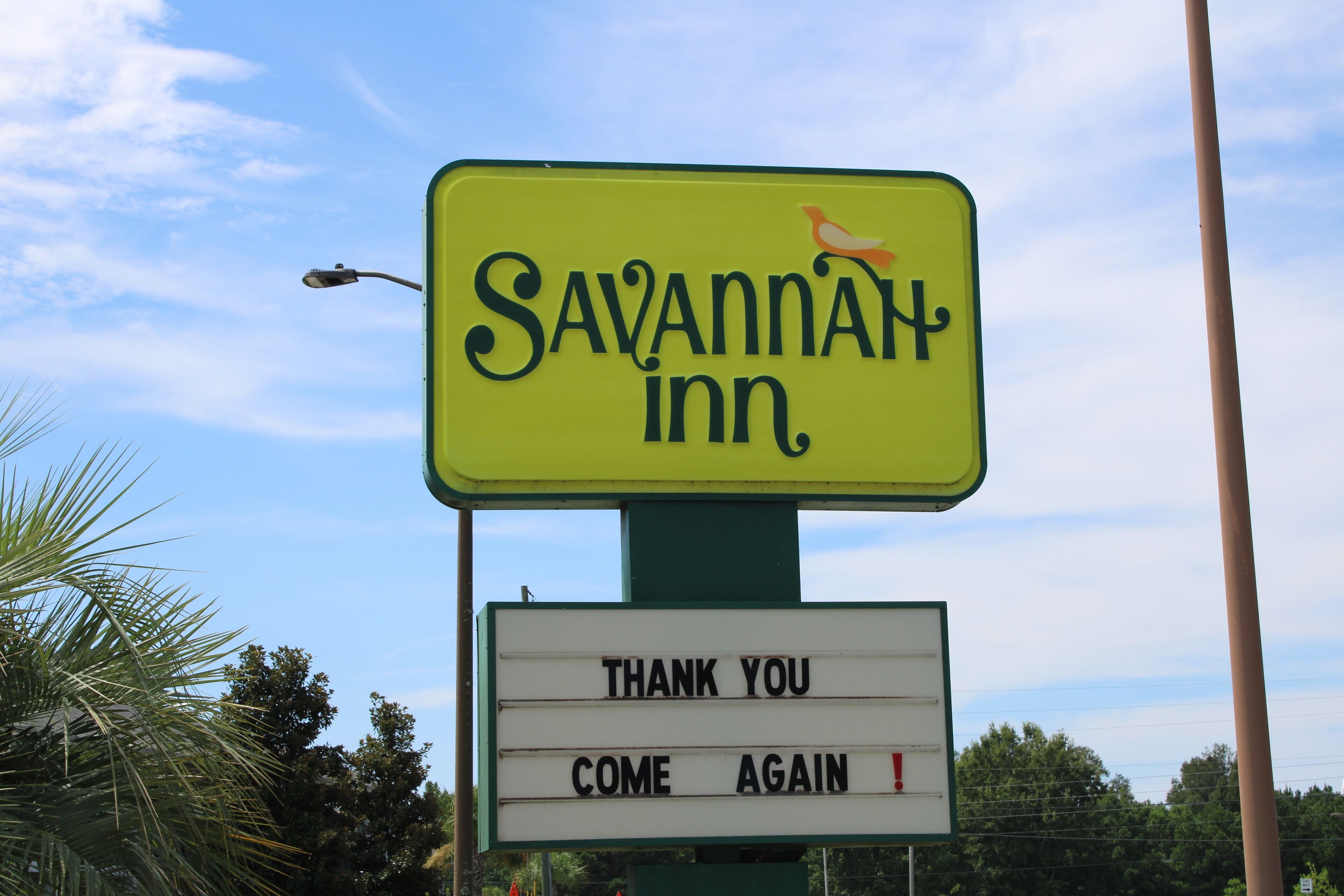 Een bord voor Savannah Inn met een prikbord eronder waarop staat: 'BEDANKT, WEES AANBEVOLEN!'