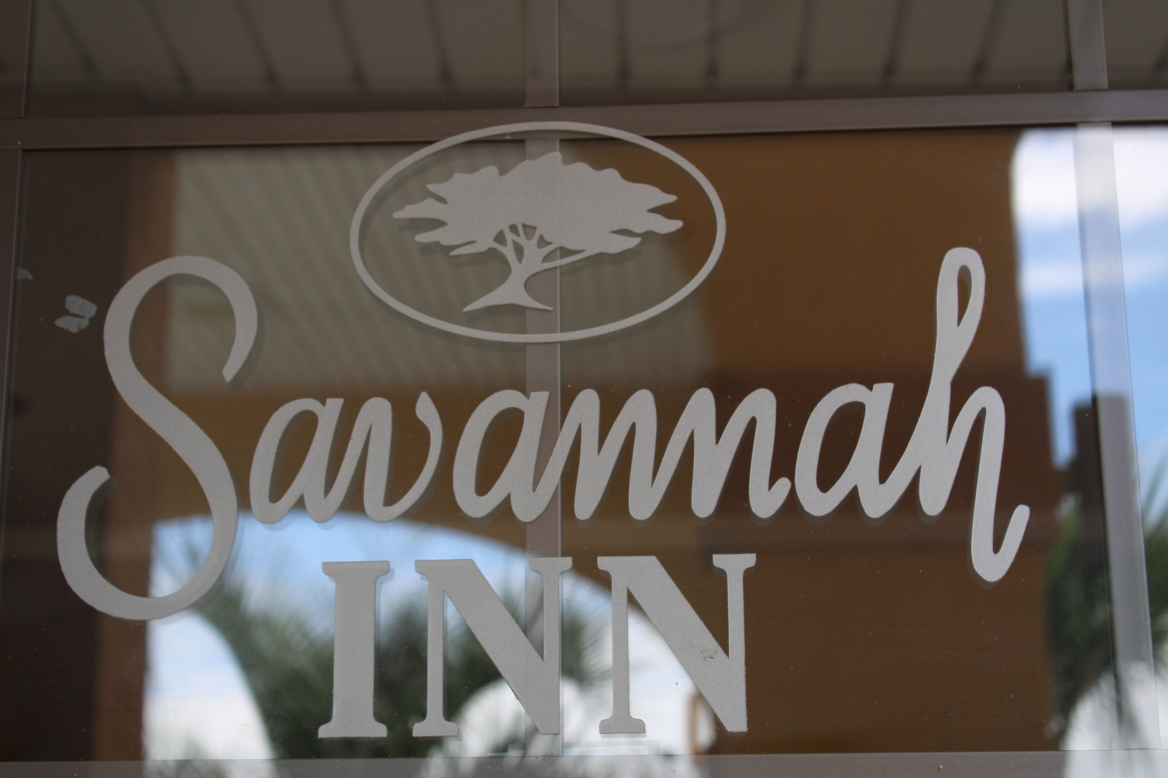 A sign with the name "Savannah Inn" and a tree logo.