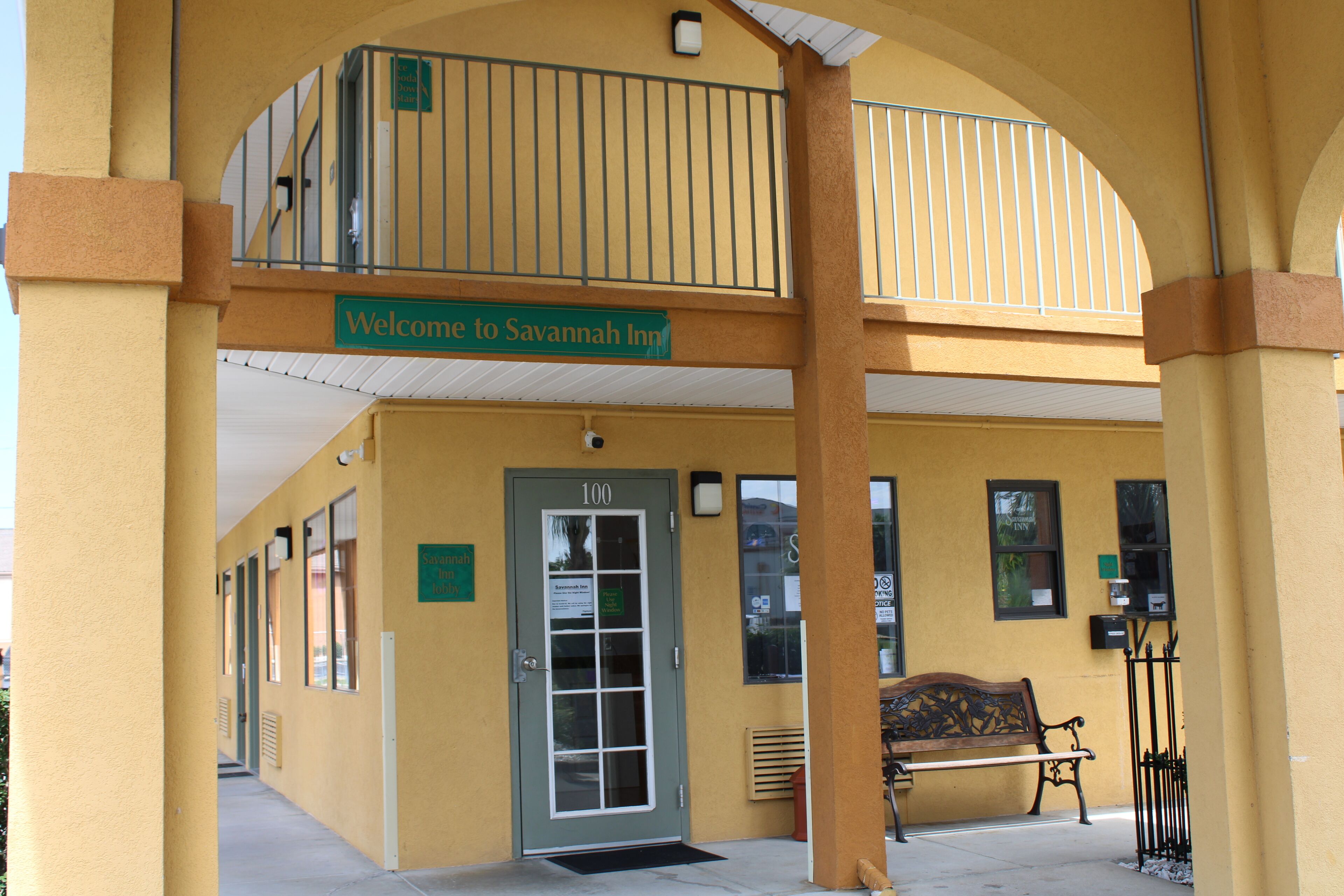 A yellow building with a sign reading "Welcome to Savannah Inn."
