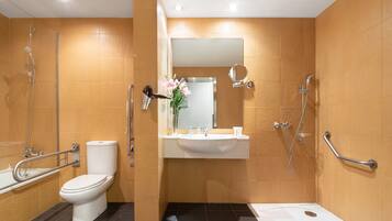 A modern bathroom with a toilet, sink, shower, and bathtub.