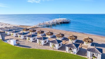 Plage privée, cabines (en supplément), chaises longues, parasols