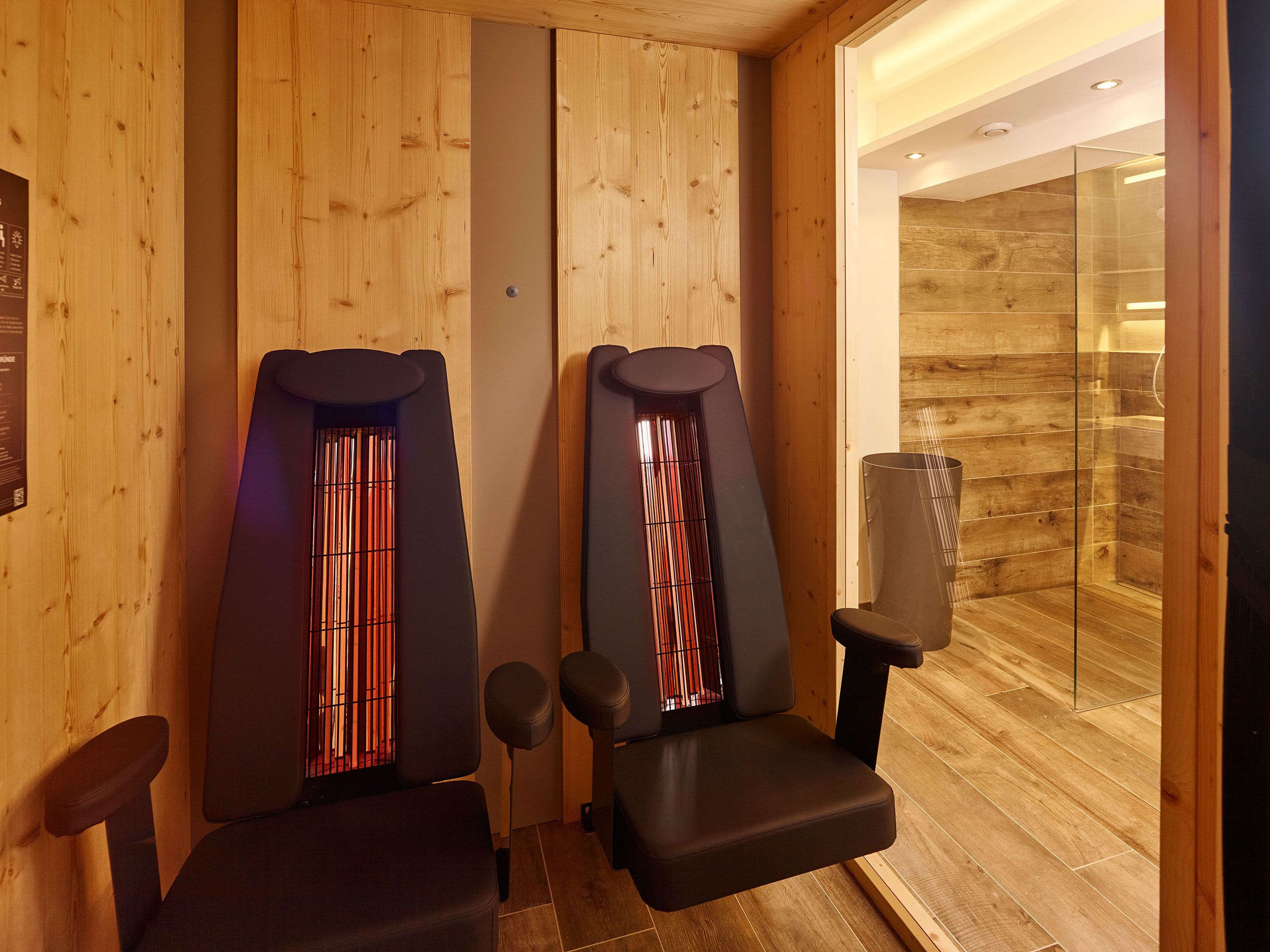 Una sala de sauna con paredes de madera y dos bancos.