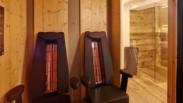 Una sala de sauna con paredes de madera y dos bancos.