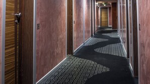 A hallway with doors on both sides, a patterned carpet, and recessed lighting. - Hotel Kore (Agrigento)