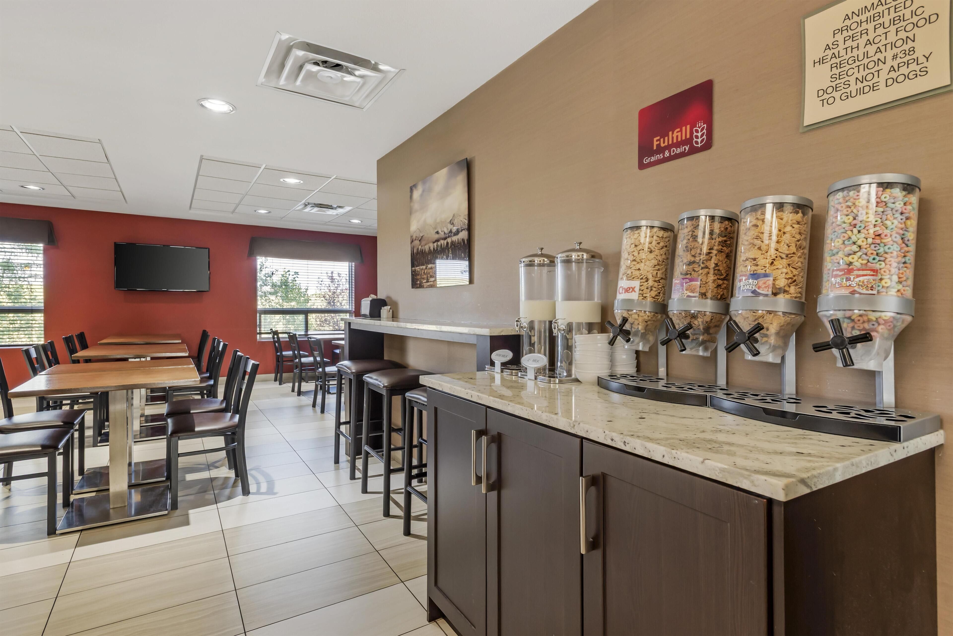 A restaurant with a bar area, seating, and food dispensers.