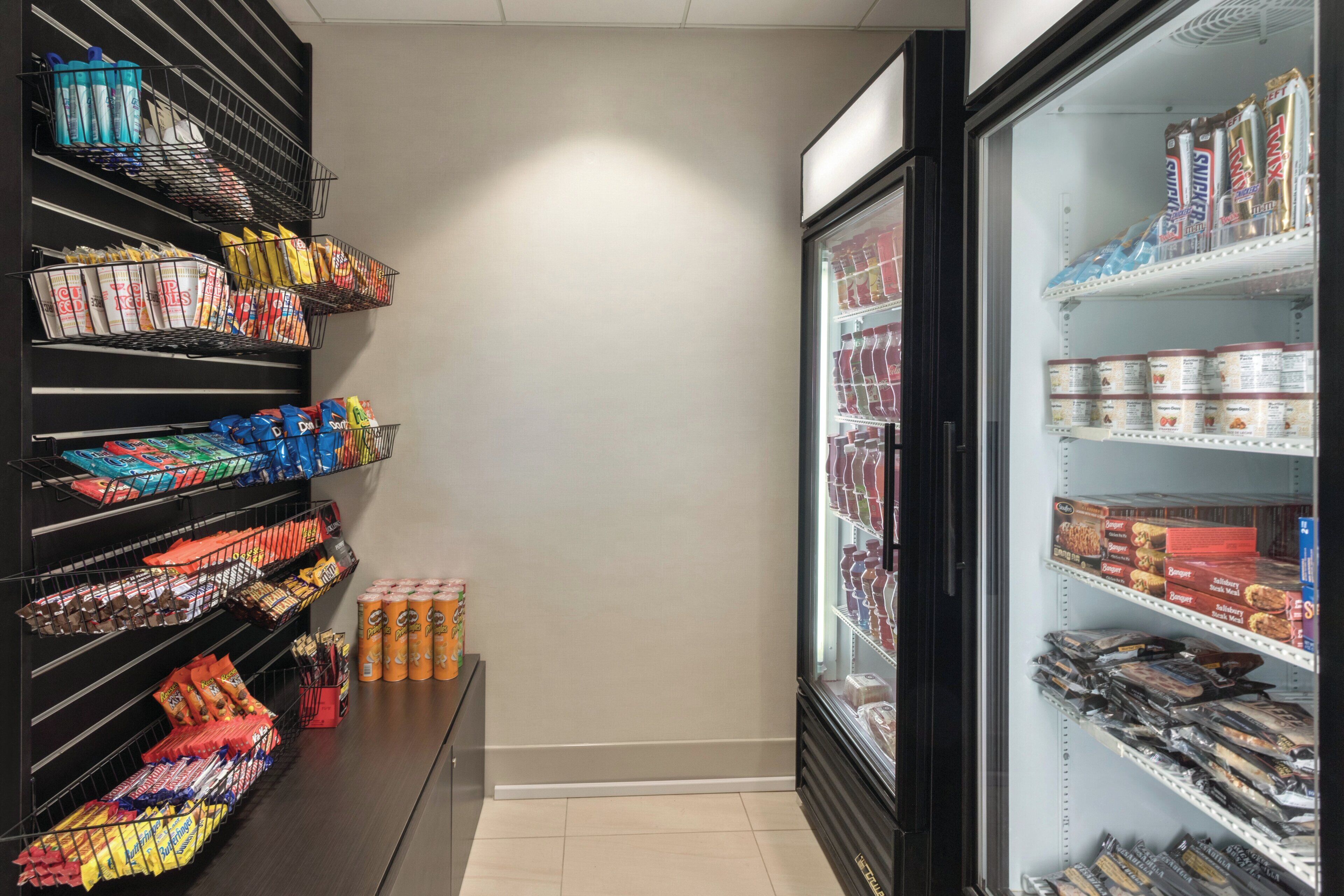 A refrigerated section with various packaged goods, a freezer with snacks, and shelves stocked with beverages and snacks.