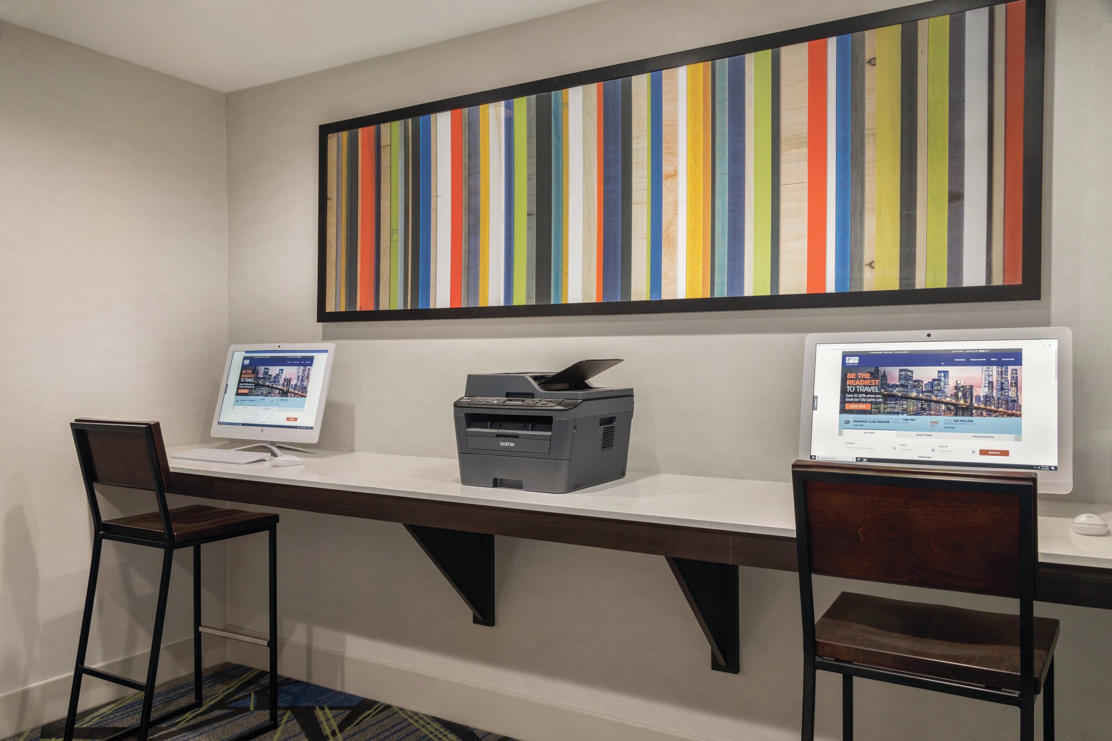 A workspace with two desks, each with a computer and a printer.